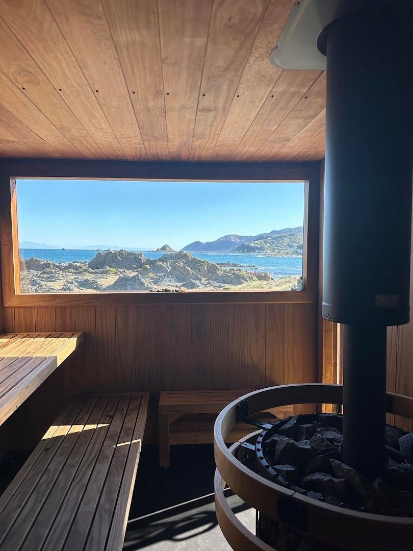 Sauna interior with stove and ocean view — why you need a sauna hat
