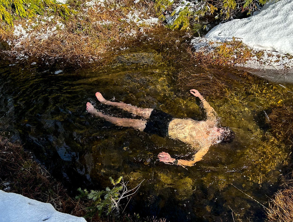 Person floating in cold natural rock pool — contrast therapy hot cold protocol