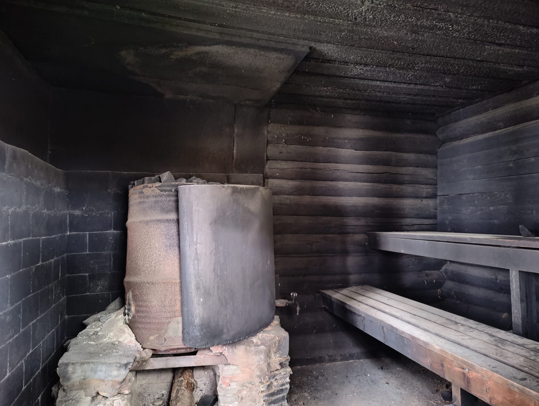 Traditional smoke sauna interior with stone stove — the ancient sauna ritual