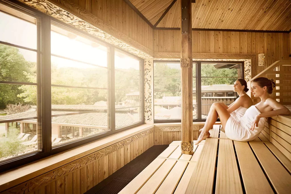 Couple relaxing in panoramic sauna — how often should you use a sauna