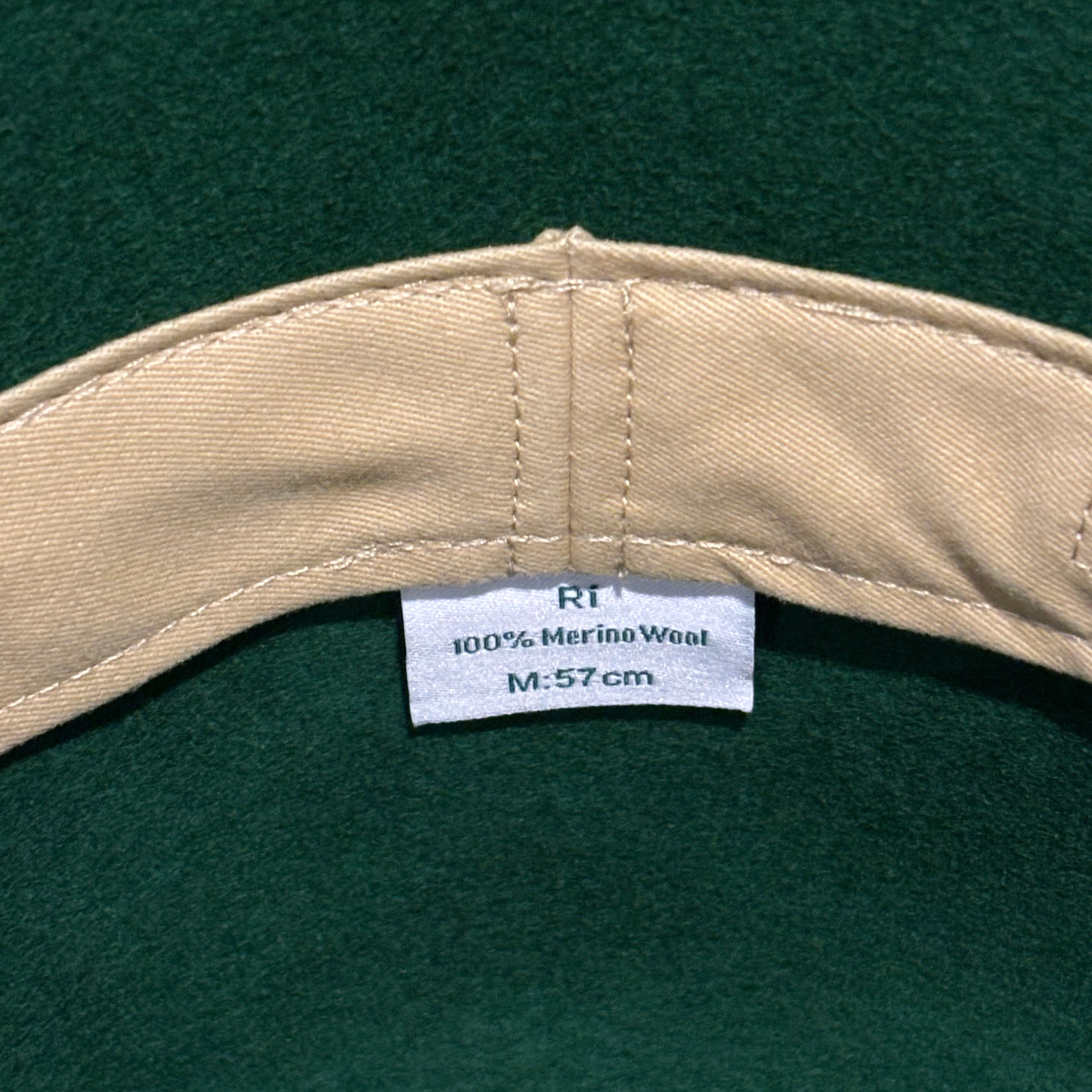 Close-up of a beige cap with a label on a green background