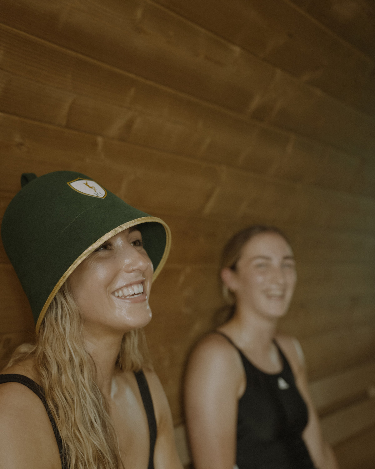 Athlete laughing in a barrel sauna wearing the Rí Sauna Crown